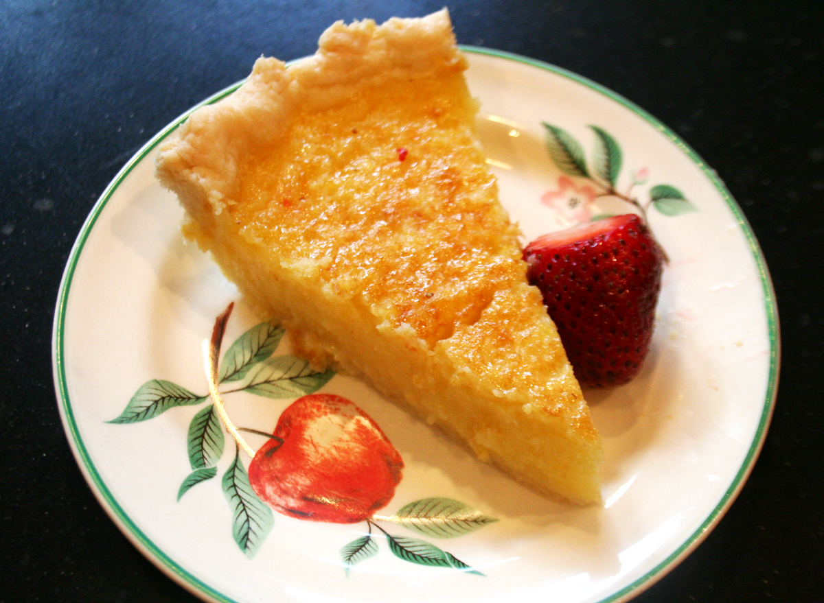 A slice of lemon chess pie, serve with fresh strawberries