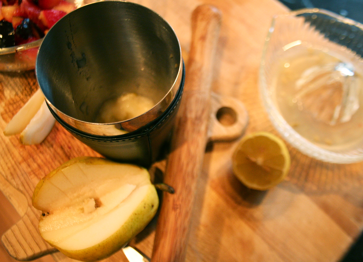 Muddling the pear slices in the cocktail shaker