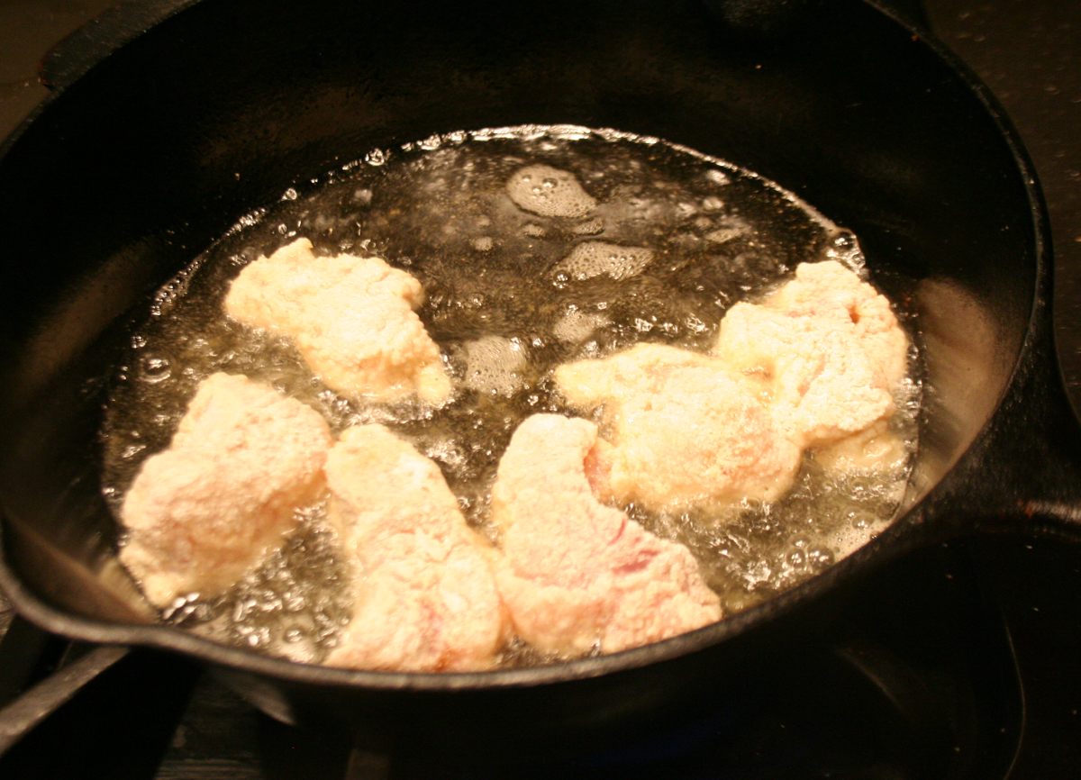 Catfish frying in an iron skillet