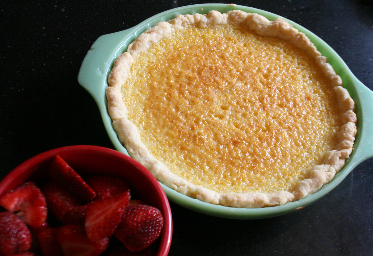 The finished lemon chess pie, waiting to be served with strawberries