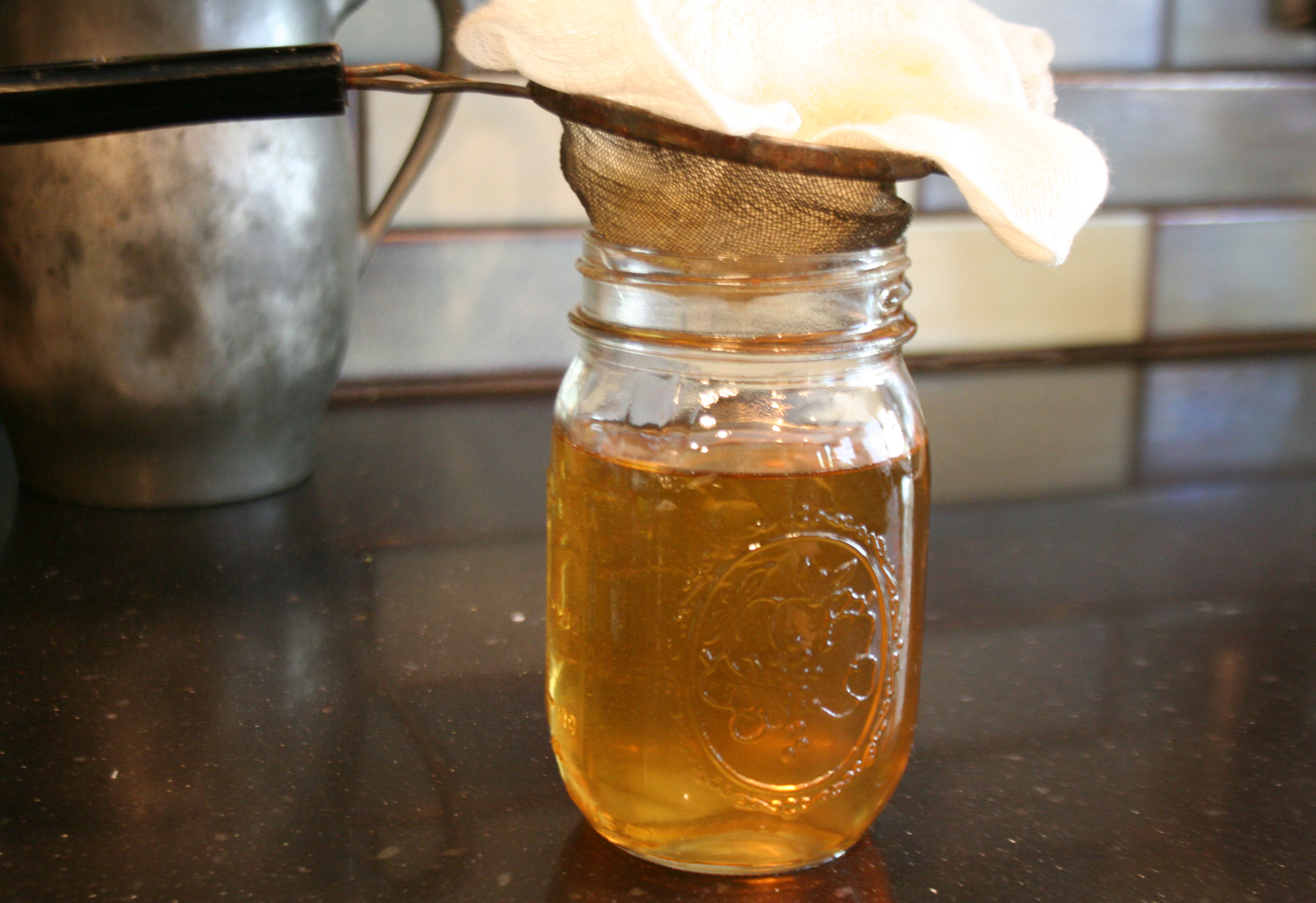 Straining the liquid lard into a jar