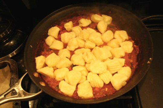 Cooked potato gnocchi tossed into the tomato sauce pan